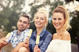 Happy group of friends eating ice-cream outdoors photo