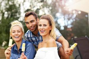 Happy group of friends eating ice-cream outdoors photo