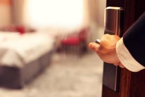 Hand of businessman opening hotel room photo