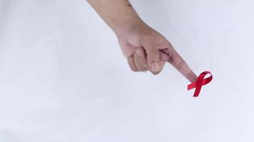 hand- symbool met rood lint betekenend bezorgdheid voor mensen met hiv AIDS geïsoleerd Aan wit achtergrond video