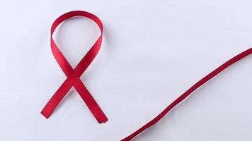 cinta de soporte roja aislada sobre fondo blanco. día mundial del sida y mes nacional de concientización sobre el vih y el envejecimiento con cinta roja video