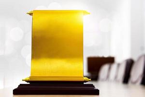 certificado, insignia de premio dorado se destaca en el escritorio. concepto de premio de empleado destacado, ganador, premio de empresa exitoso. foto