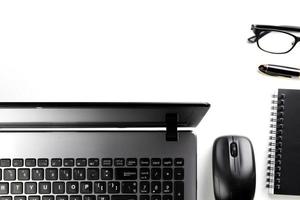 top view of modern white office desk with computer keyboard, blank notebook page and other equipment on white background. Workspace concept, workspace management style, business design space with copy photo