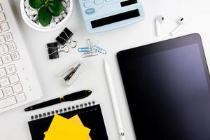 Top view modern white desk with tablet computer for graphic design, book pages and other accessories on  white background workspace concept, workspace style, online meetings, freelance work for copy photo