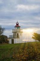 Lighthouse, Spodsbjerg Fyr in Huntsted on the coast of Denmark. Sun rays shining photo