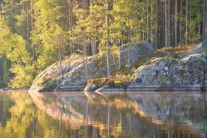 Stone rocks with conifers by the lake in Sweden in Smalland. Nature in Scandinavia photo