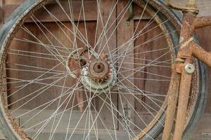 viejas ruedas de bicicleta sin usar almacenadas en la parte trasera de la casa, solo el cable y el cubo de la rueda en la sala de almacenamiento con el viejo suelo de tablas como la parte trasera foto