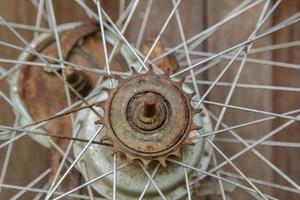 viejas ruedas de bicicleta sin usar almacenadas en la parte trasera de la casa, solo el cable y el cubo de la rueda en la sala de almacenamiento con el viejo suelo de tablas como la parte trasera foto