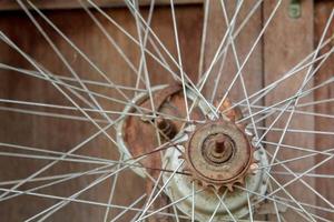 Old unused bicycle wheels stored in the back of the house, only the wire and wheel hub in the storage room with old board flooring as the back photo