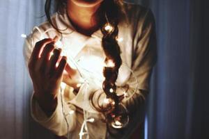 mujer sosteniendo luces de hadas foto