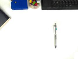 escritorio blanco plano en la oficina con espacio de diseño.con equipo de oficina como lápices, cuadernos y teclados en la parte superior.mesa simulada foto