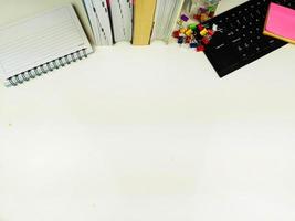 Flat lay, white desk in the office with layout space.with office equipment such as pencils, notebooks and keyboards at the top.mock up table photo