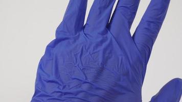 Close up of Hand wear purple latex gloves on white background. photo