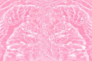 Defocus blurred transparent pink colored clear calm water surface texture with splashes and bubbles. Trendy abstract nature background. Water waves in sunlight with copy space. Pink watercolor shining photo