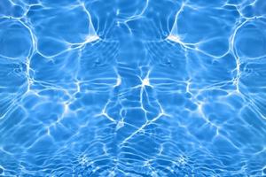 Defocus blurred transparent blue colored clear calm water surface texture with splashes and bubbles. Trendy abstract nature background. Water waves in sunlight with copy space. Blue watercolor shining photo