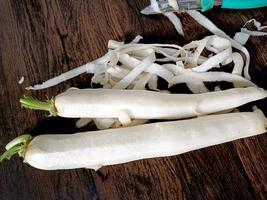 White radish placed on a simple wooden table photo