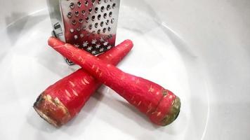 Lots of fresh red and sweet peeled carrots kept in a plate photo