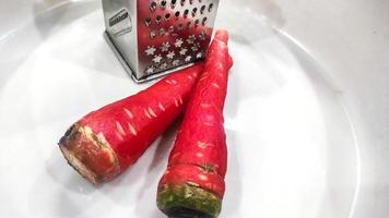 Lots of fresh red and sweet peeled carrots kept in a plate photo