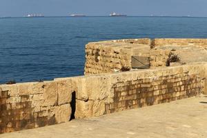 Stone wall of an ancient fortress on the seashore in Israel. photo