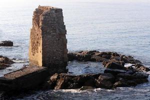 Stone wall of an ancient fortress on the seashore in Israel. photo