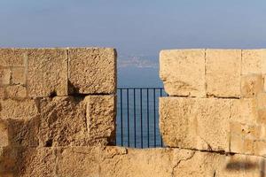 Stone wall of an ancient fortress on the seashore in Israel. photo