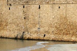 Stone wall of an ancient fortress on the seashore in Israel. photo