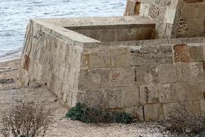 Stone wall of an ancient fortress on the seashore in Israel. photo