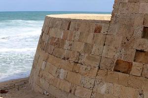 Stone wall of an ancient fortress on the seashore in Israel. photo