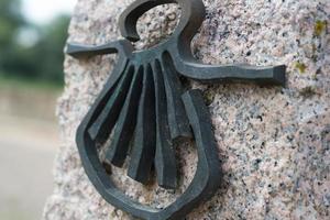 Milestone with a shell, the symbol of Santiago way. photo