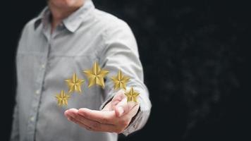 mano del cliente o cliente que sostiene las estrellas para completar cinco estrellas con espacio de copia. calificación de servicio, otorgando una calificación de cinco estrellas. concepto de satisfacción. foto