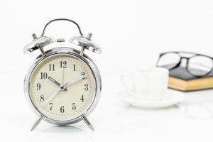 Silver alarm clock with old books photo