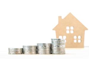 House model and stack of coins on table photo