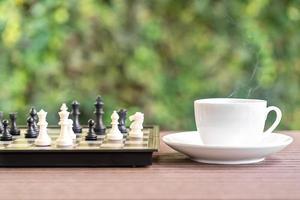 Coffee cup on wood table with Chess board photo