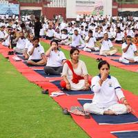 New Delhi, India, June 21 2022 - Group Yoga exercise session for people at Yamuna Sports Complex in Delhi on International Yoga Day, Big group of adults attending yoga class in cricket stadium photo