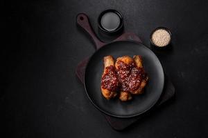 Tasty spicy chicken legs with teriyaki sauce and sesame seeds photo