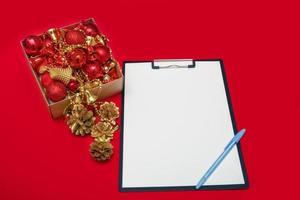 blank white sheet with a pen next to a box of christmas toys photo