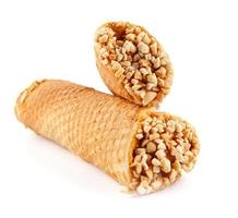 Tube waffles with boiled condensed milk and crushed peanuts are isolated on a white background . photo