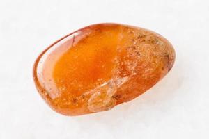 polished Spessartine garnet gemstone on white photo