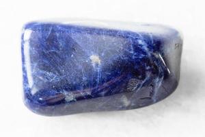 polished Sodalite rock on white marble photo