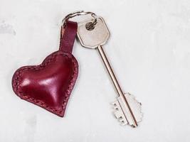 key with heart shape keychain on concrete plate photo