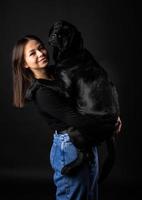 A girl holds a Labrador Retriever dog in her arms. photo