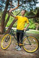 un joven tomándose un selfie con su bicicleta. foto