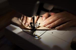 la mujer está cosiendo con máquina de coser. la costura es una de las artes textiles más antiguas. foto