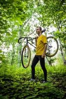 un joven se detuvo a descansar con su bicicleta en un parque público. foto