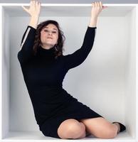 Beautiful portrait of a girl in a white cube sitting photo