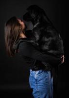 A girl holds a Labrador Retriever dog in her arms. photo