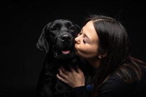 A girl holds a Labrador Retriever dog in her arms. photo