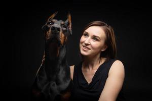 Portrait of a Doberman dog with a girl owner. photo