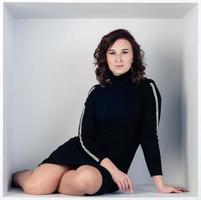 Beautiful portrait of a girl in a white cube sitting photo