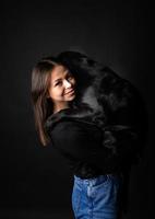 A girl holds a Labrador Retriever dog in her arms. photo